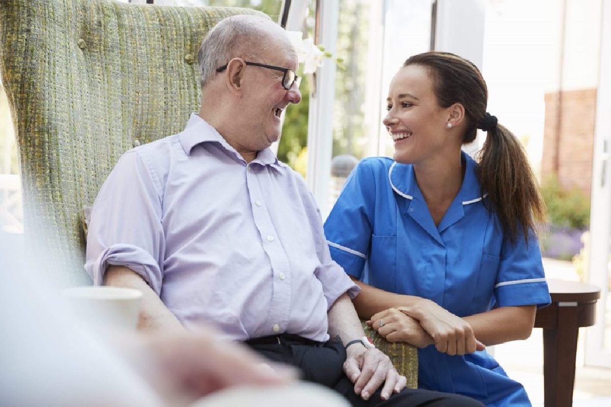 Senior im Gespräch mit einer Pflegekraft